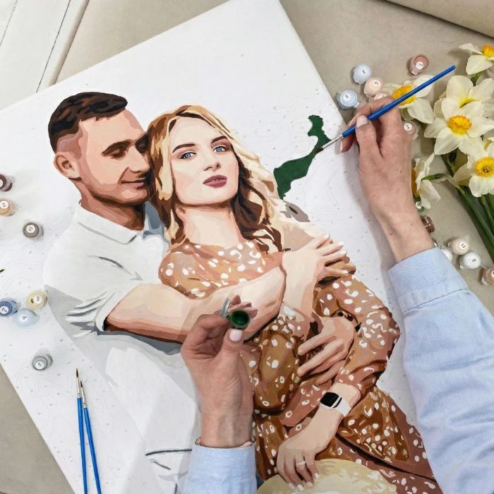 Hands painting a custom couple portrait on canvas, romantic DIY paint by numbers kit for anniversary or wedding gift.
