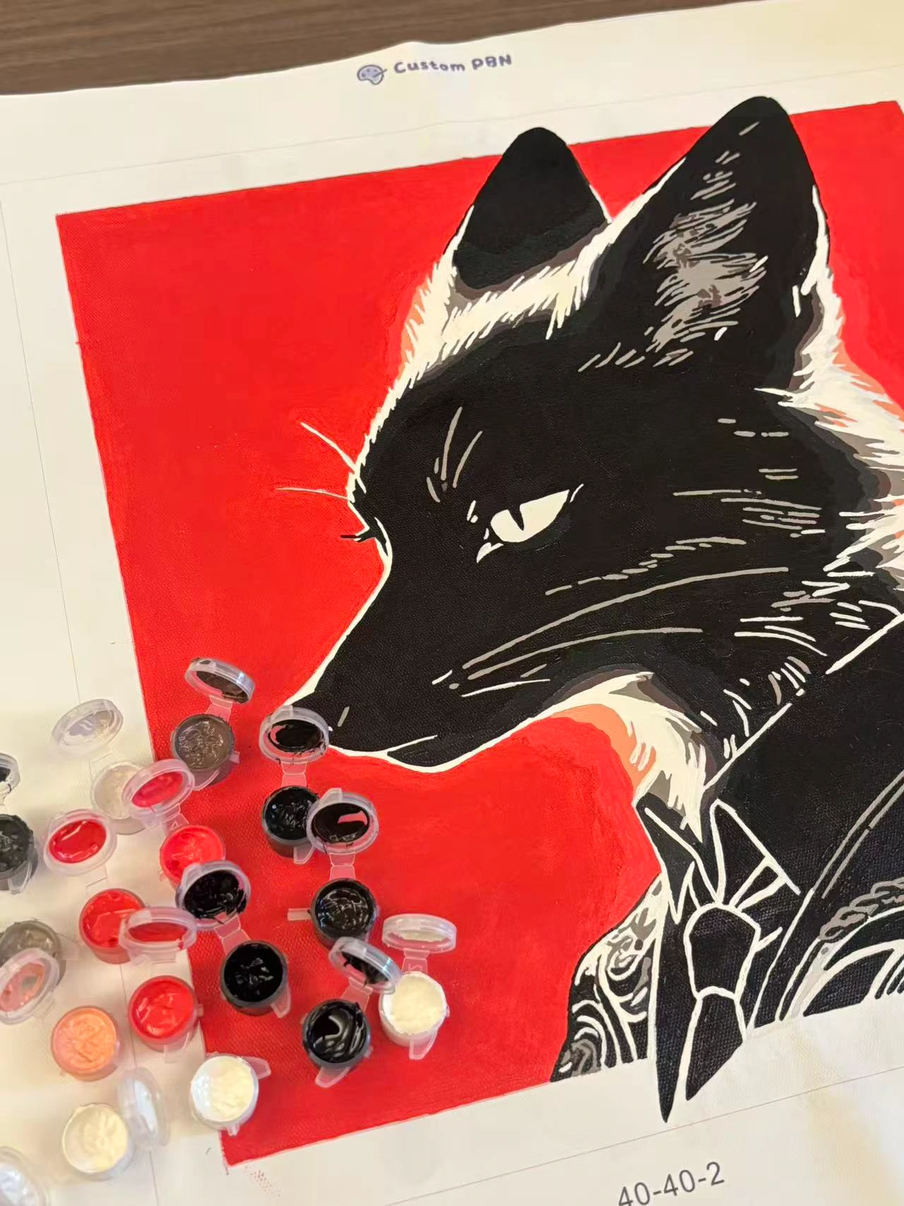 Completed custom paint by numbers canvas of a black fox with plenty of extra paint left in the pots.