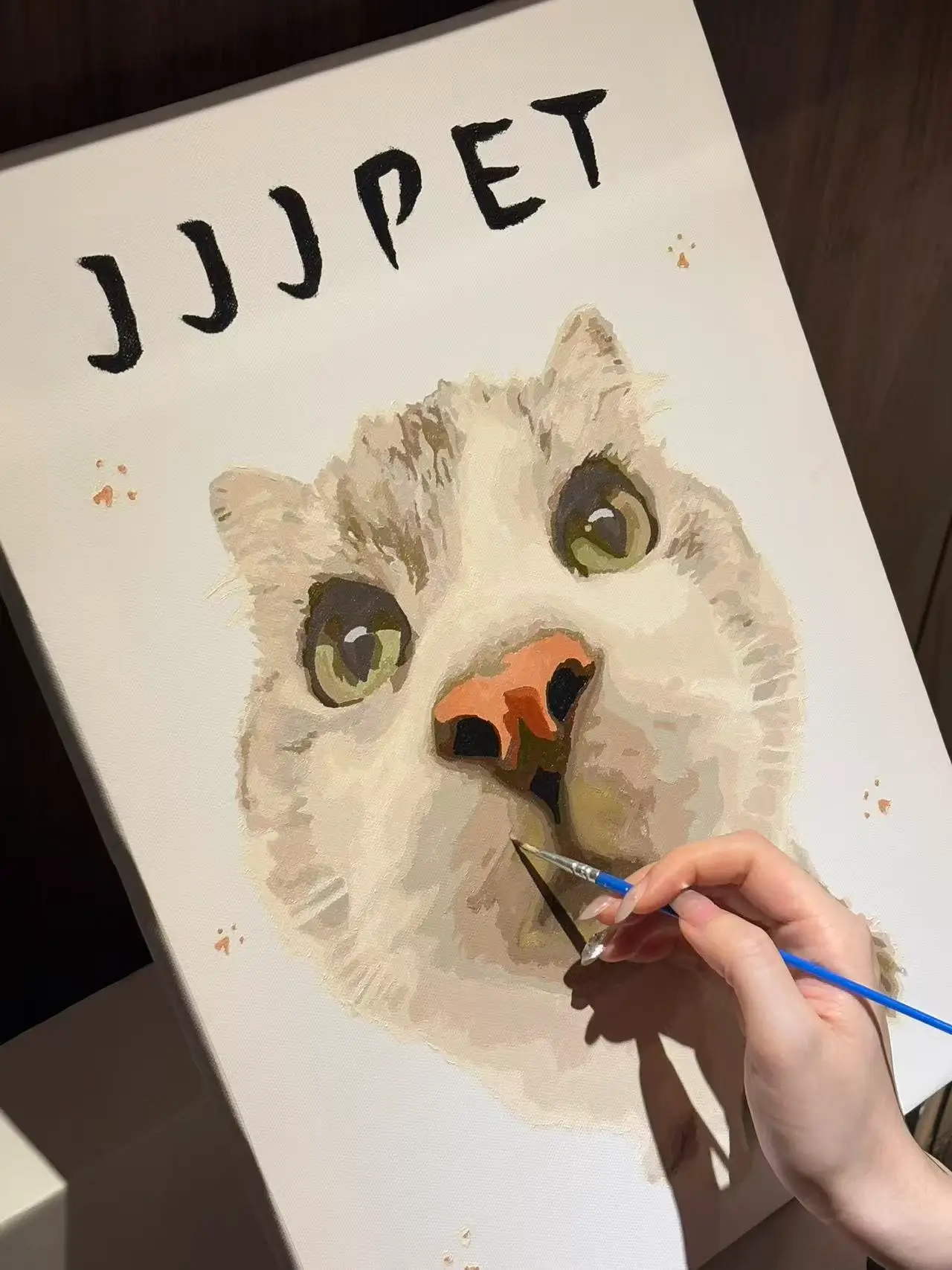 Blank numbered canvas of a custom pet paint by number kit, showing a person holding a small paint pot and brush ready to begin painting a cat.