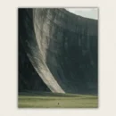 Enormous curved concrete wall towering over a green field with one tiny standing figure paint by numbers finished canvas